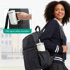 A woman wearing a navy cardigan and skirt carries a black laptop backpack with side pockets, demonstrating its capacity for a