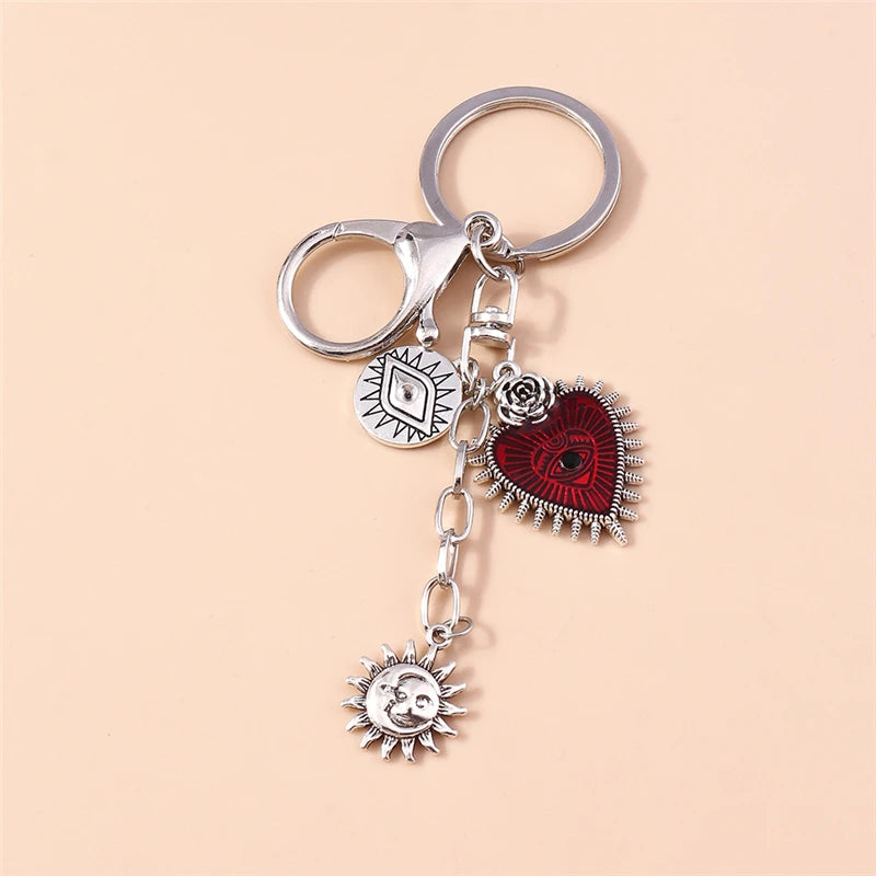 Silver gothic steampunk heart keychain featuring a sun eye pendant and decorative elements