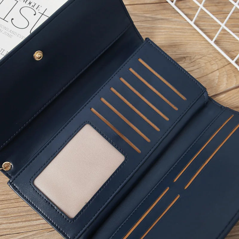 A dark navy waterproof nylon crossbody bag with gold trim and a beige interior is shown open on a wooden surface.