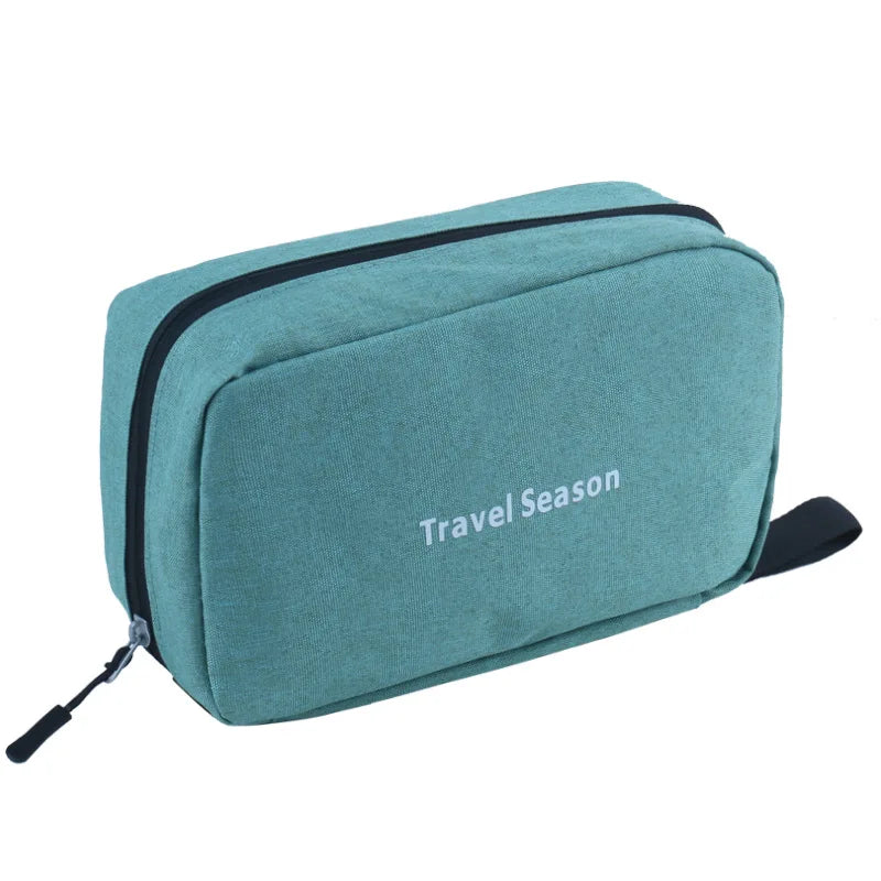 Sac de toilette voyage en tissu imperméable couleur sarcelle avec bordure et sangle noires.