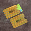 Two yellow card sleeves with RFID protection markings are displayed on a dark brown surface.