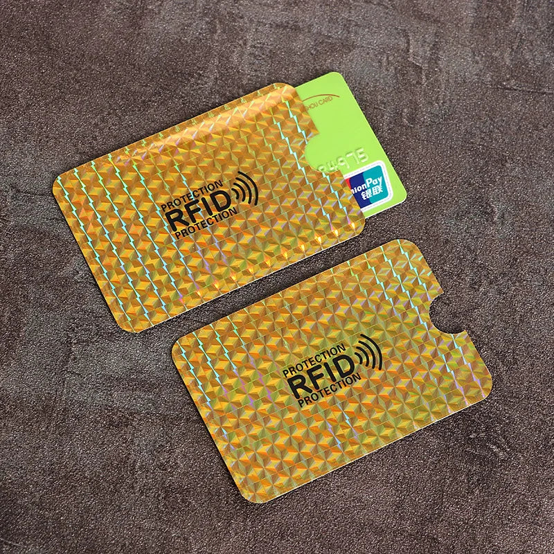 Two yellow card sleeves with RFID protection markings are displayed on a dark brown surface.