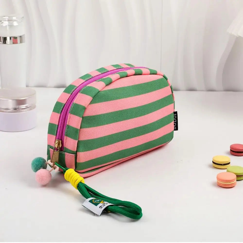 Clutch de tejido rayado hecho a mano en rosa y verde con borla amarilla.