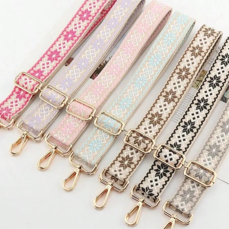 A collection of replacement bag straps in various pastel and patterned fabrics with metal adjusters.