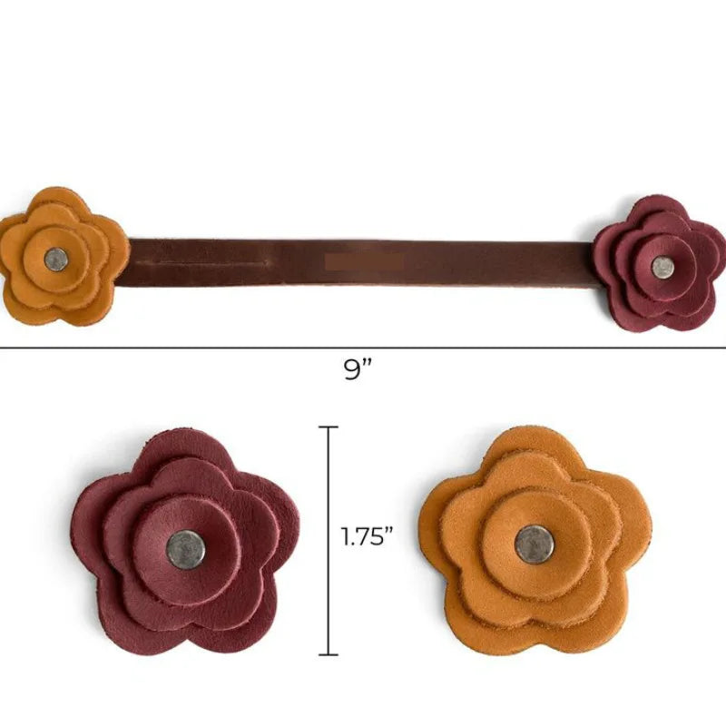 A brown leather rose bag charm with a flat bar and two flower-shaped pieces.