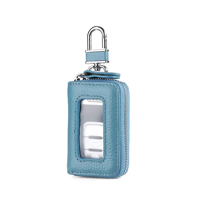 A light blue leather car key case with a transparent window and a silver padlock hook.