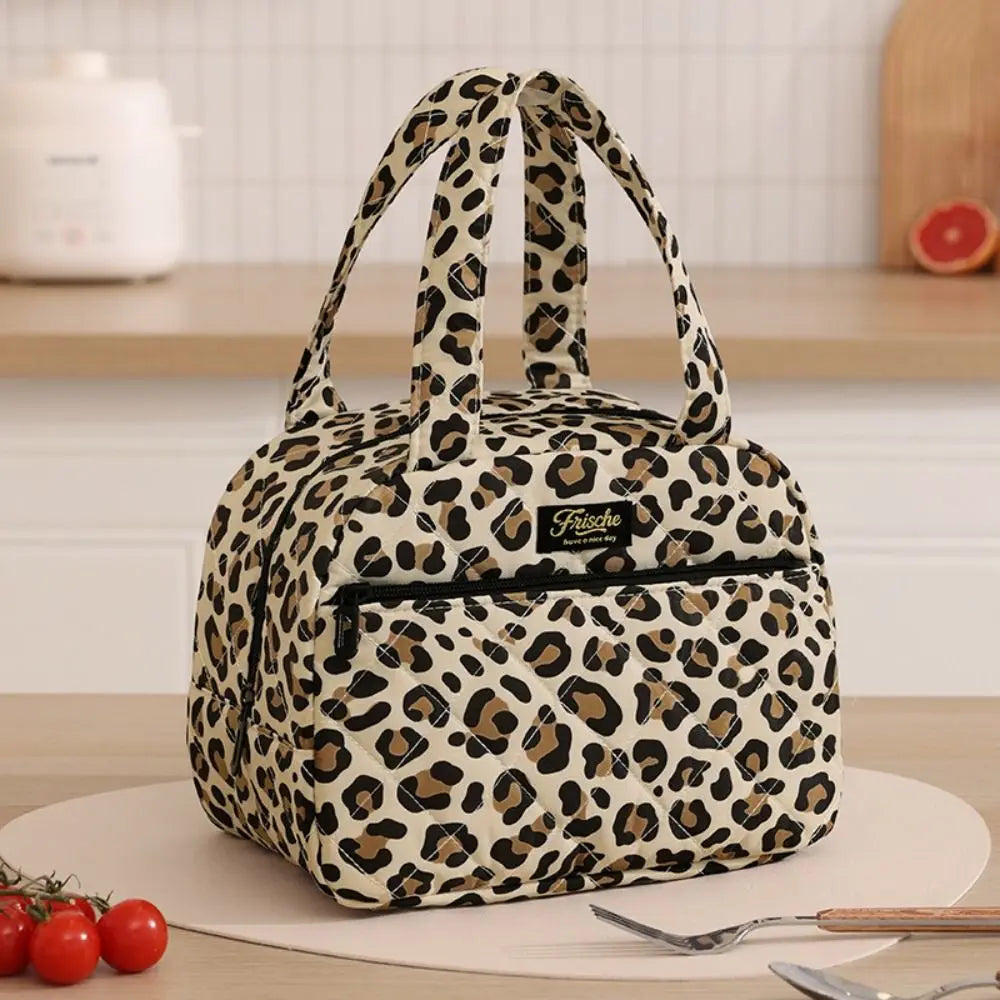 A patterned leopard print insulated lunch tote bag resting on a white surface.