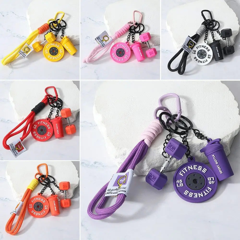 A collection of detachable dumbbell keychain charms in various colors and styles, including yellow, pink, and black.