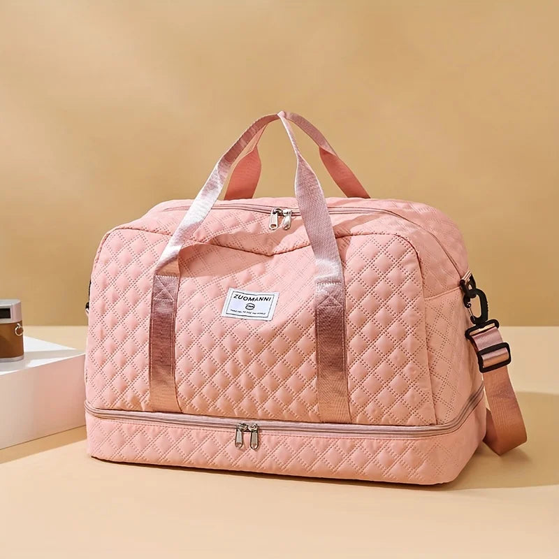 A pink quilted nylon travel duffle bag with pink straps resting on a light beige surface.