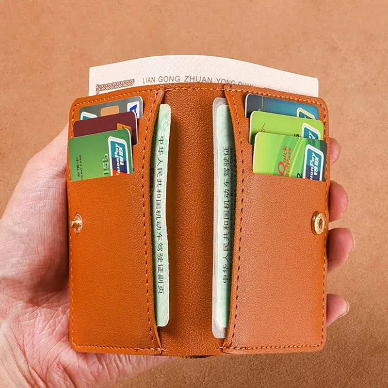 A brown PU leather small wallet holding several credit cards and an ID card.