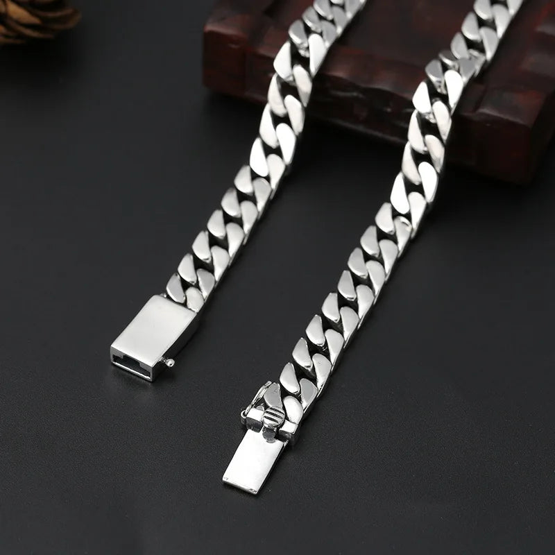 A pair of sterling silver punk charm bracelets with padlock clasps displayed on a dark surface.