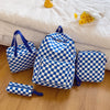 A blue and white checkerboard multi-pocket backpack resting on a white towel.