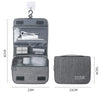 Sac portable gris en tissu avec plusieurs compartiments et une sangle de transport.