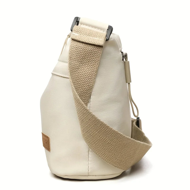 A beige nylon crossbody shoulder bag with a tan strap and multiple zippered compartments.