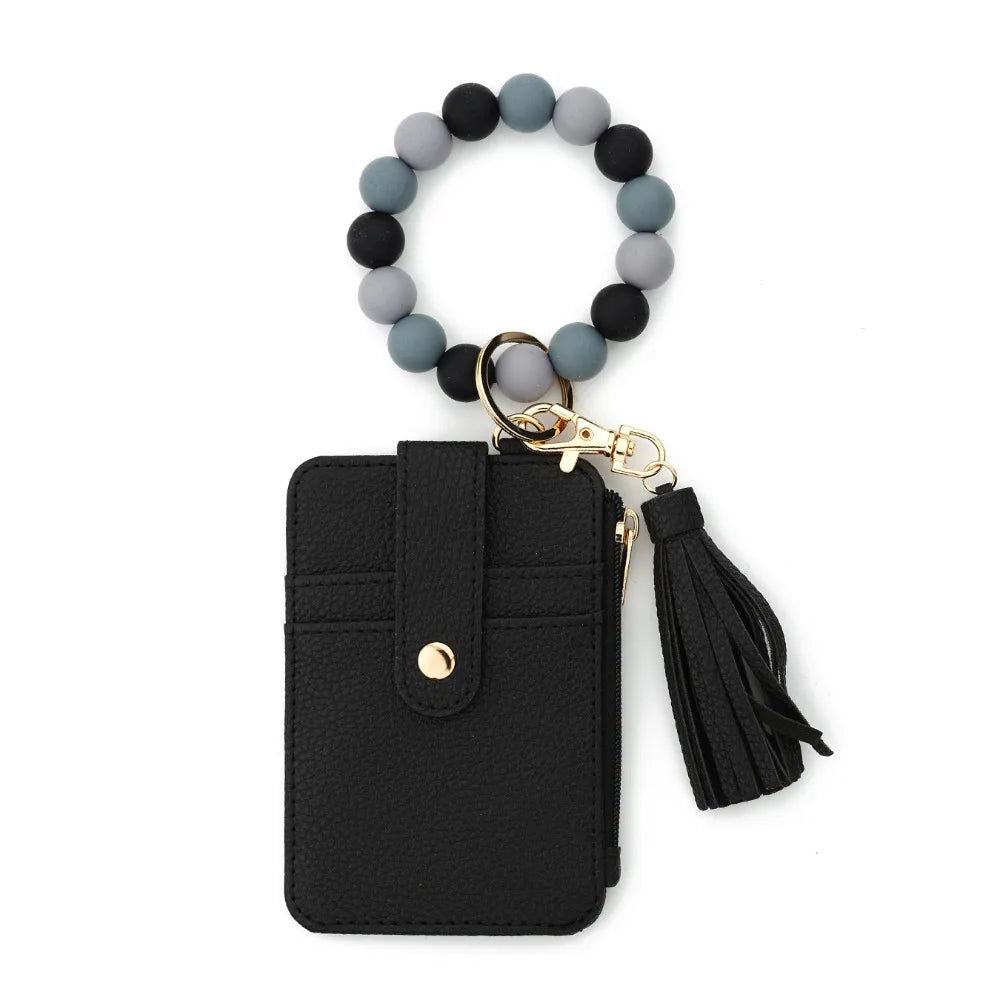 Black leather wristlet keychain featuring a beaded bracelet and tassel.