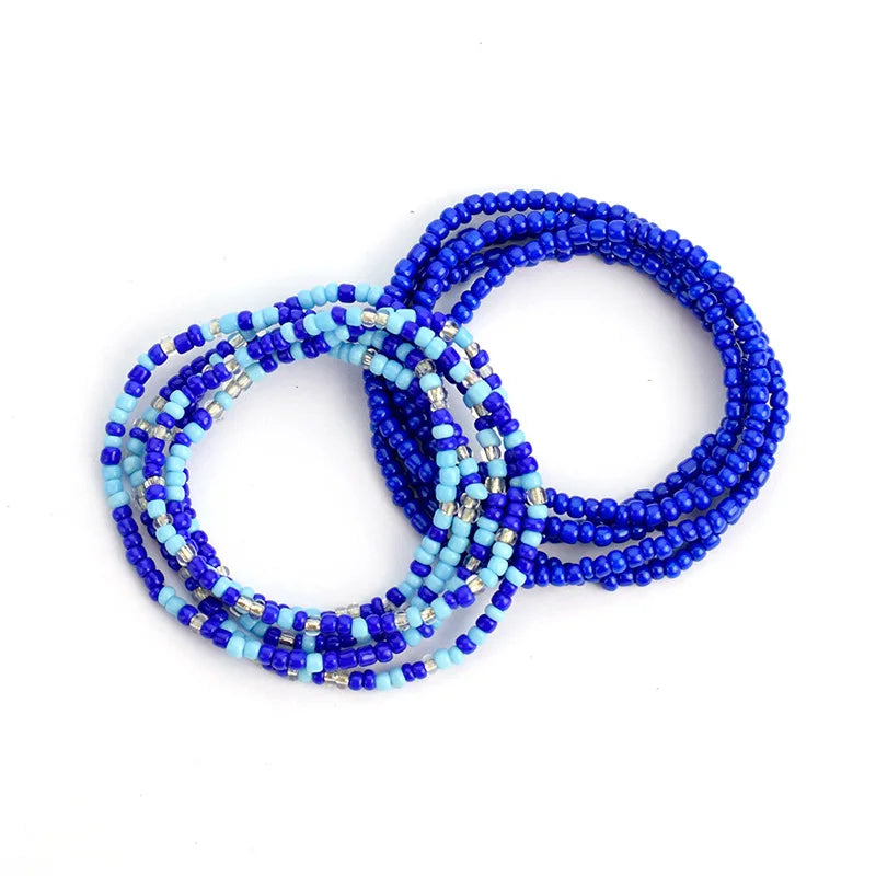 A stack of colorful belly bead chains featuring blue and turquoise beads for body jewelry.
