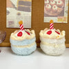 Two fluffy white and light blue bread-shaped plush keychains with red and white striped straws.