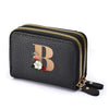 Black faux leather mini wallet with a gold zipper and a rose floral letter print