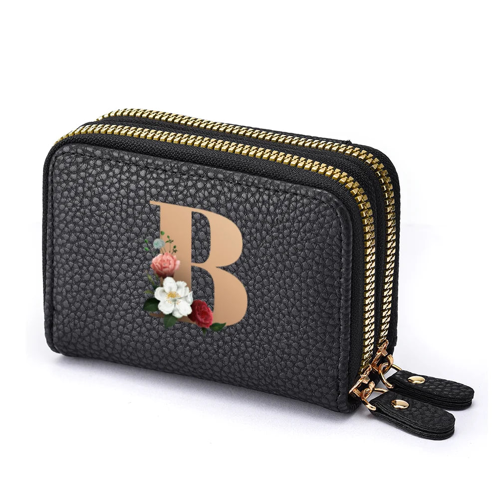 Black faux leather mini wallet with a gold zipper and a rose floral letter print