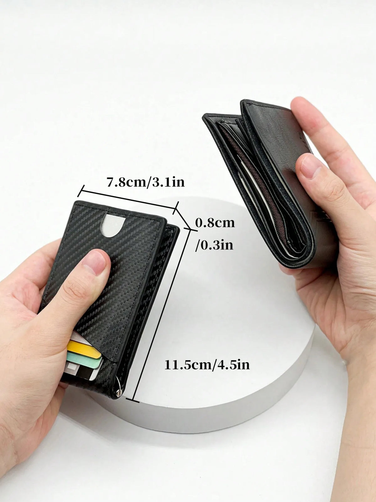 Una mano sostiene un estuche para tarjetas de fibra de carbono negra, mostrando sus dimensiones y diseño.