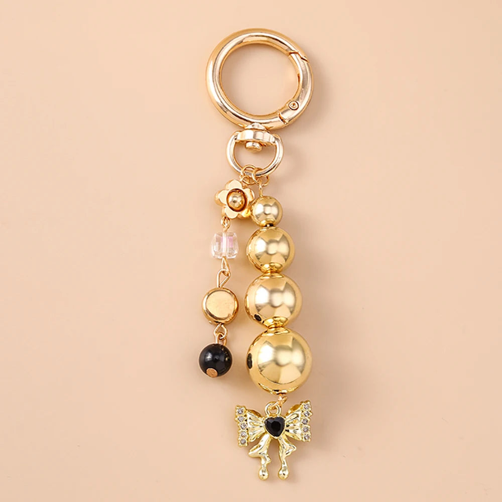 Gold pearl bow heart keychain with a jump ring and dangling beads for bags and keys