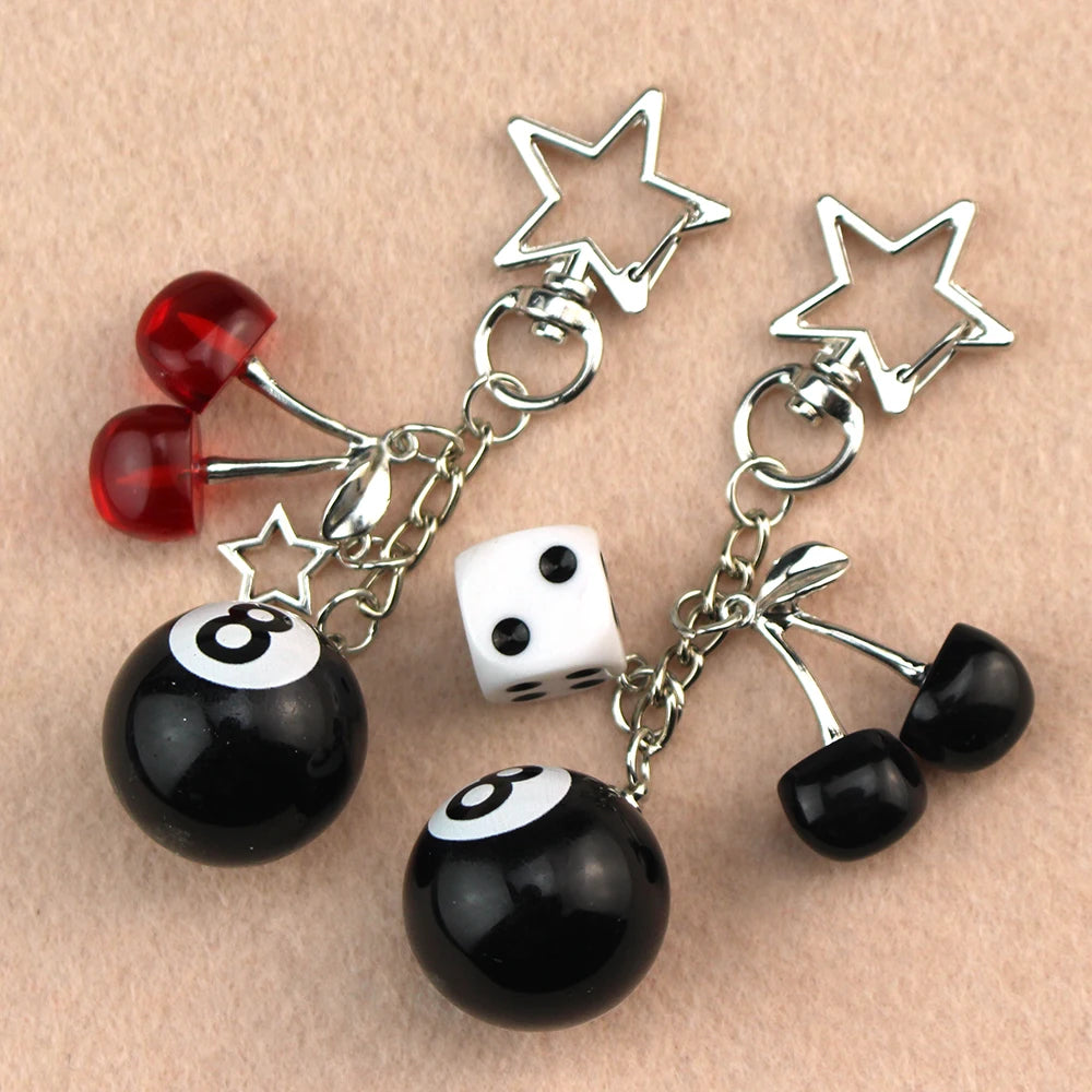 Silver Y2K 8 ball keychain charm featuring black and white spheres and a star.