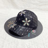 A black mesh snapback baseball cap decorated with sparkling floral embroidery on the front.