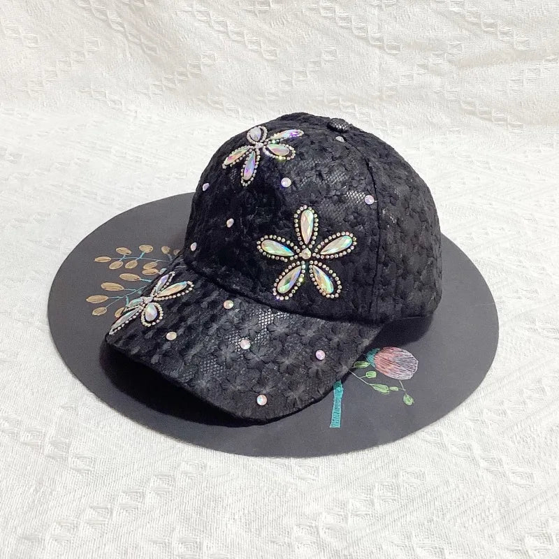 A black mesh snapback baseball cap decorated with sparkling floral embroidery on the front.