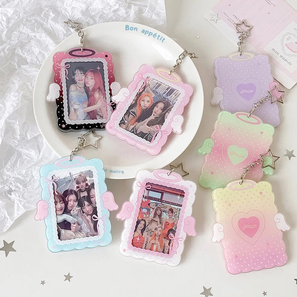 A collection of pink and purple angel wings photocard holders with clear display cases on a white plate.