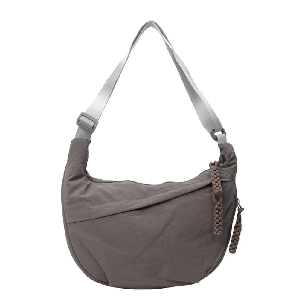 A gray canvas crossbody shoulder bag with adjustable straps.