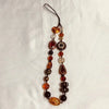 A necklace featuring various amber, brown, and clear glass beads on a black cord.