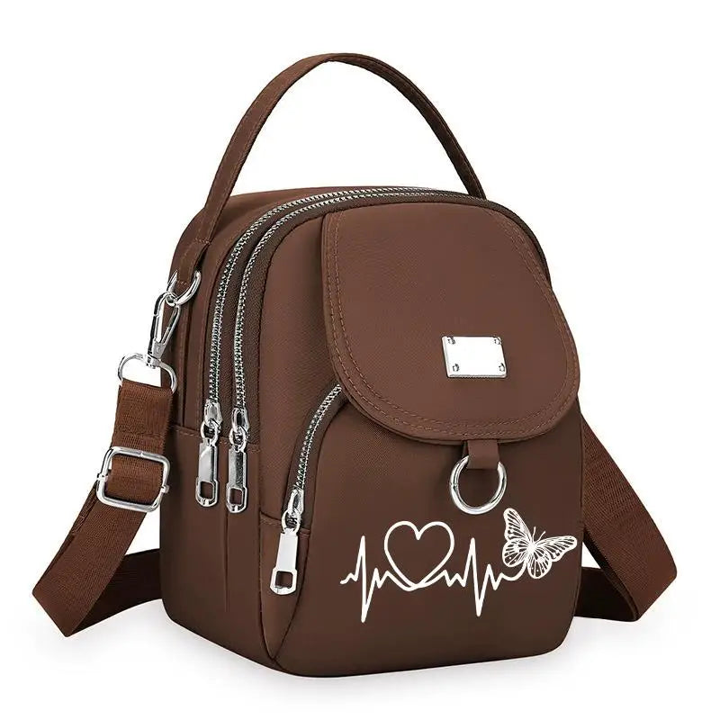 Sac bandoulière floral marron et durable avec fermeture éclair et motif cœur sur le devant.