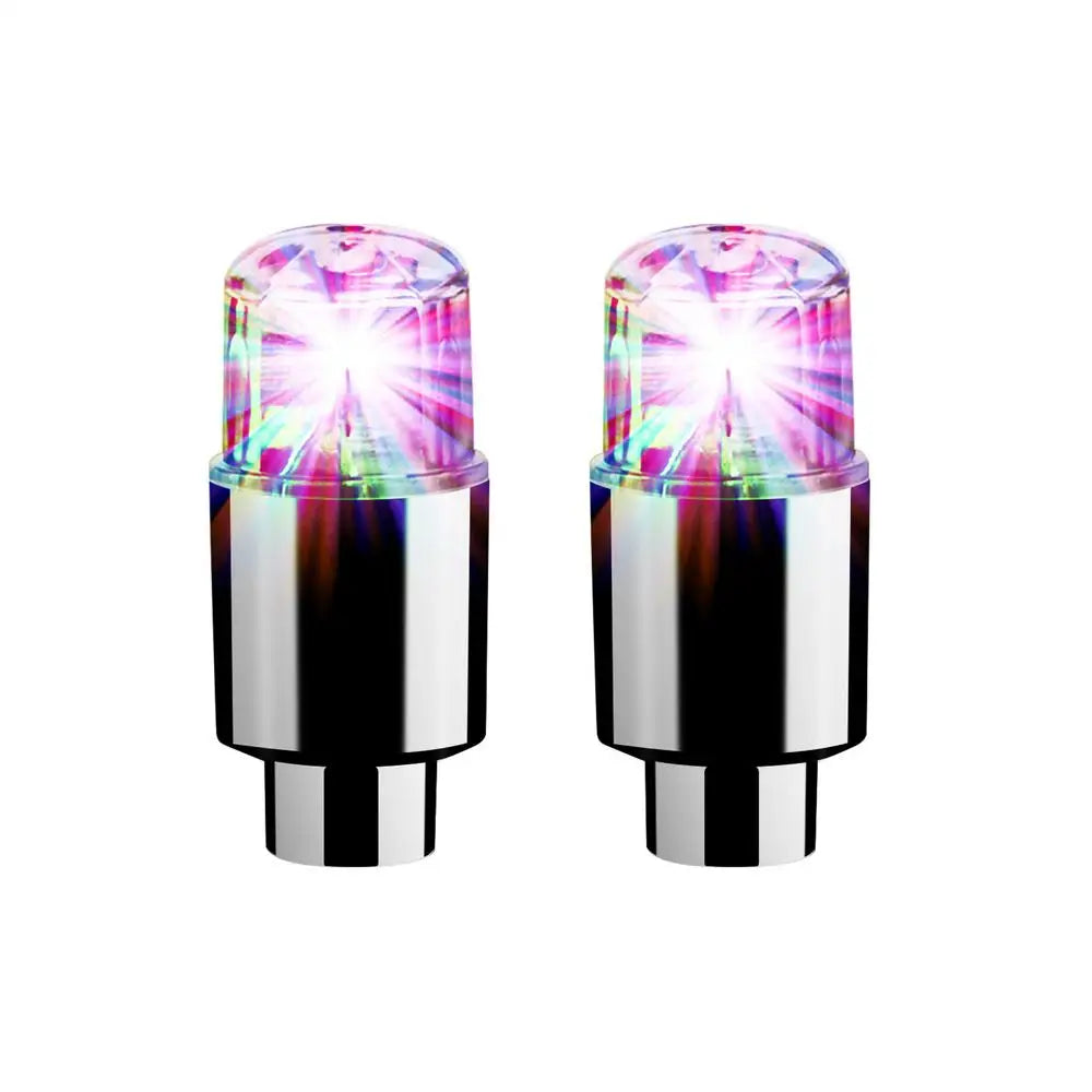 A pair of LED tire valve stem lights with clear lenses and metallic bases.