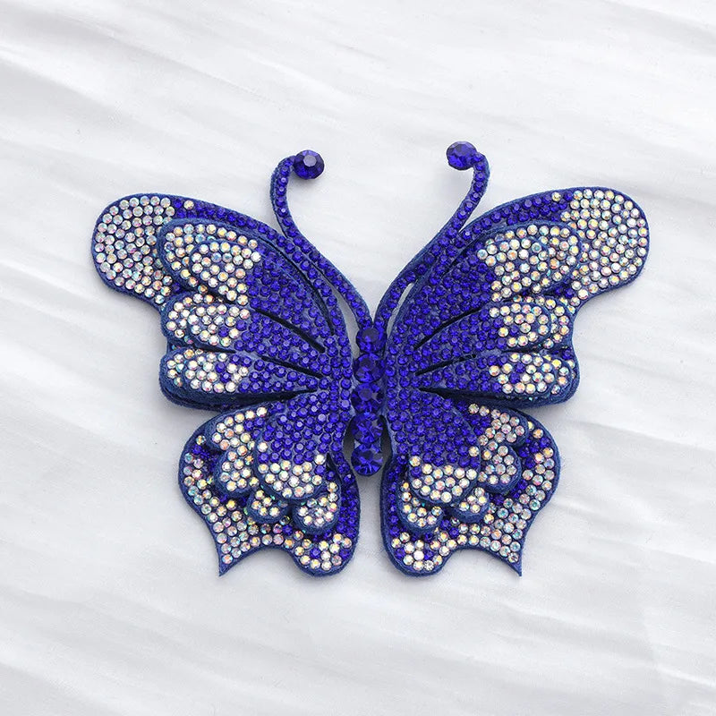 A vibrant royal blue butterfly made of sparkling rhinestones and sequins.