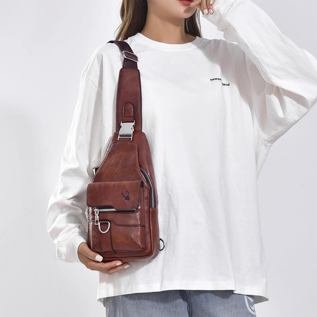 A white long-sleeved shirt with a brown PU leather crossbody sling bag worn on the shoulder.