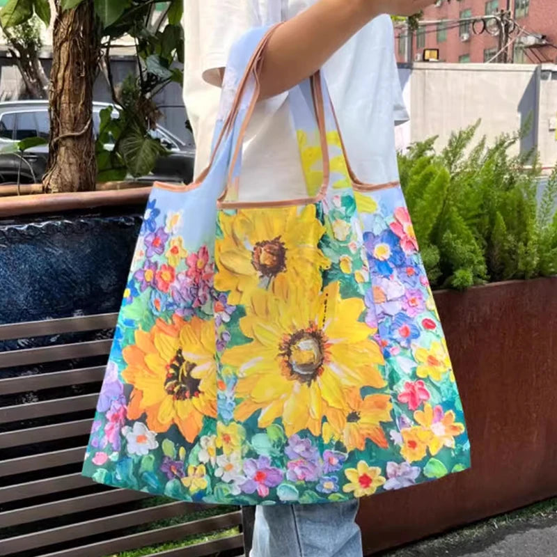 A woman holds a colorful floral print nylon shopping tote bag with a tan strap outdoors.
