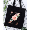 Black canvas tote bag featuring a large gold letter Z design with a pink floral print