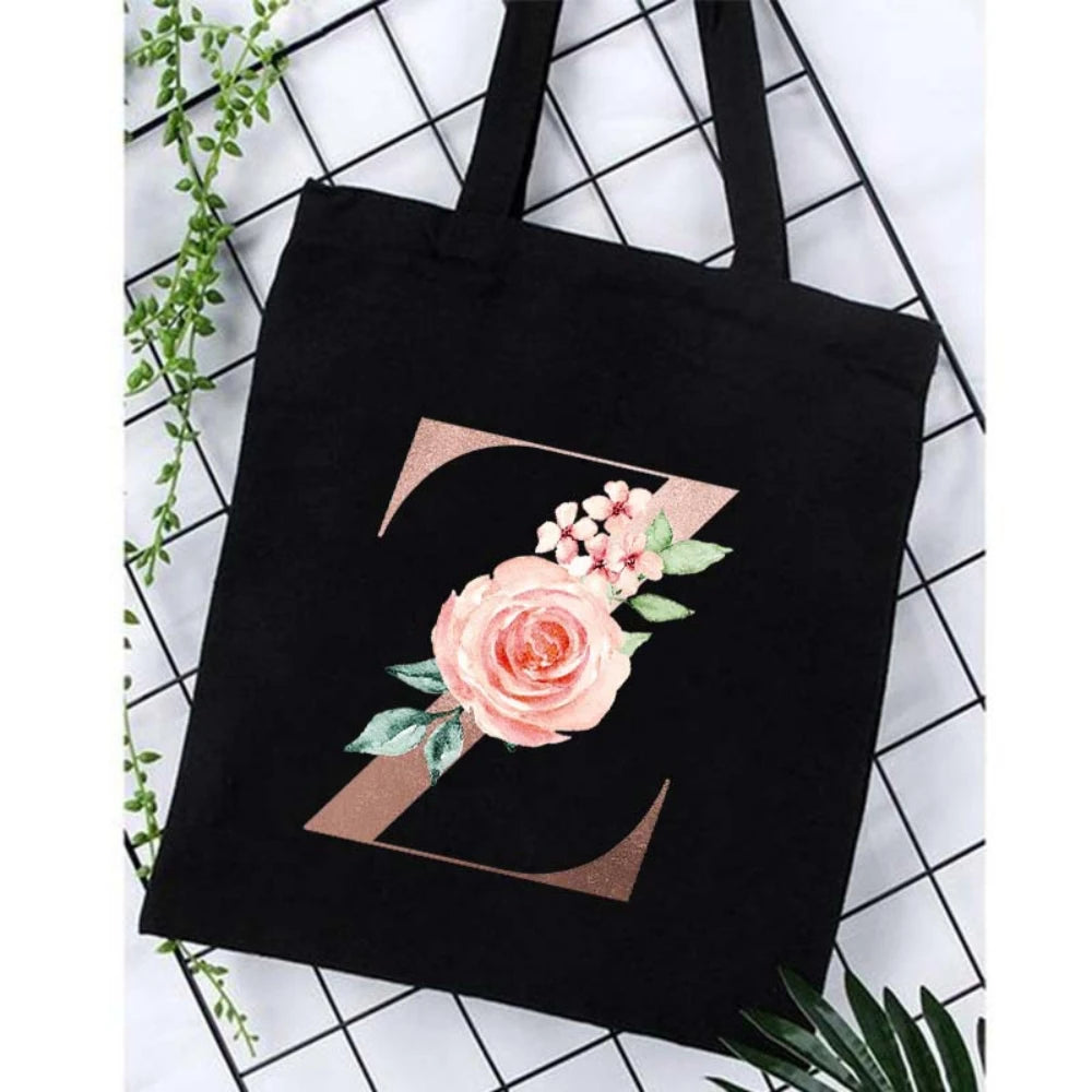 Black canvas tote bag featuring a large gold letter Z design with a pink floral print