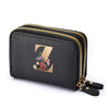 Black mini wallet with a gold zipper and a floral letter print on the front