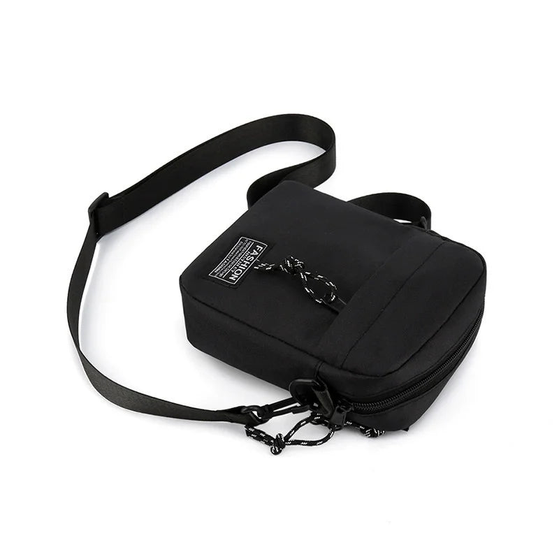 Schwarze, kompakte Crossbody-Tasche mit Riemen und Kettendetail