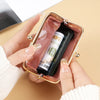 A hand holds a retro candy-colored coin purse with a gold buckle, inside which is a rolled-up banknote.