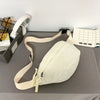 A beige corduroy waist pack for women is displayed on a gray cloth next to a white grid organizer.
