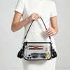 Une femme tient un sac à épaule transparent en PVC avec une sangle noire et divers accessoires.