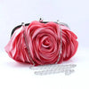 A vibrant pink rose floral evening clutch bag with a silver chain strap.