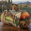A quilted travel duffle bag featuring a desert landscape design with cacti and sunset colors.