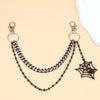 Silver metal purse chain strap with a black spider pendant displayed on a beige background
