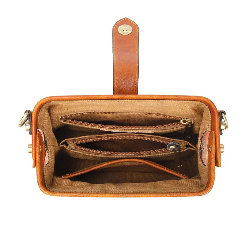 A tan genuine leather crossbody bag with a brown leather strap and buckle closure.
