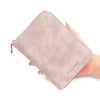 A light pink passport wallet with a gold airplane logo is held in a hand.