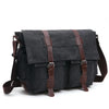 A dark gray canvas messenger bag for men with brown leather straps and buckles.