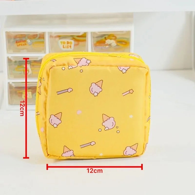 A yellow compact pouch designed for storing sanitary pads or tampons, featuring cute pink and yellow designs.
